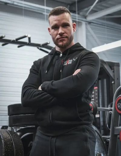 Frank, co-gérant et coach sportif, bras croisés dans la salle