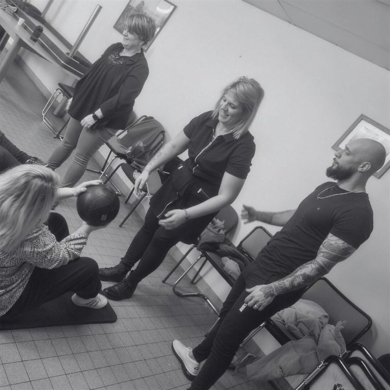Des salariés en exercice avec un coach, pendant un team building